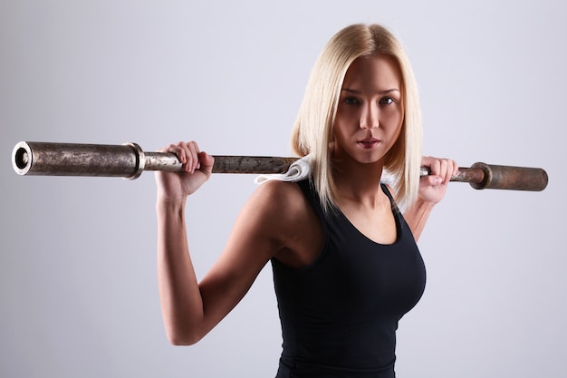 Mujer joven atleta con barra de ejercicio