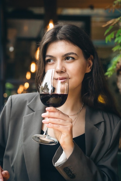 Mujer joven atractiva con una copa de vino en un restaurante