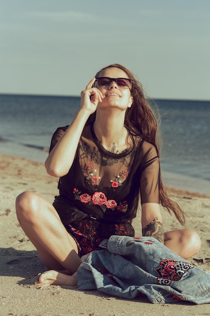 Mujer joven atractiva en la playa del océano al atardecer