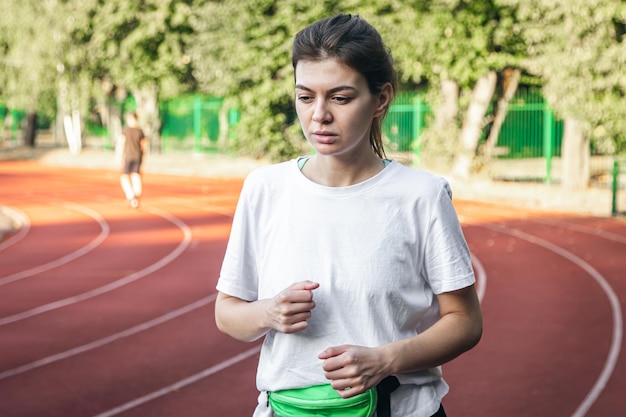 Foto gratuita mujer joven atractiva en ropa deportiva corriendo en el estadio