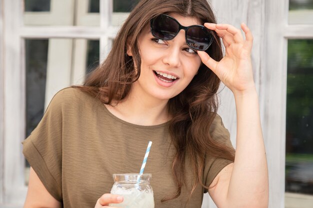Mujer joven atractiva con un vaso de limonada en un caluroso día de verano