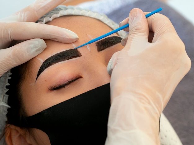 Foto gratuita mujer joven atravesando un procedimiento de microblading