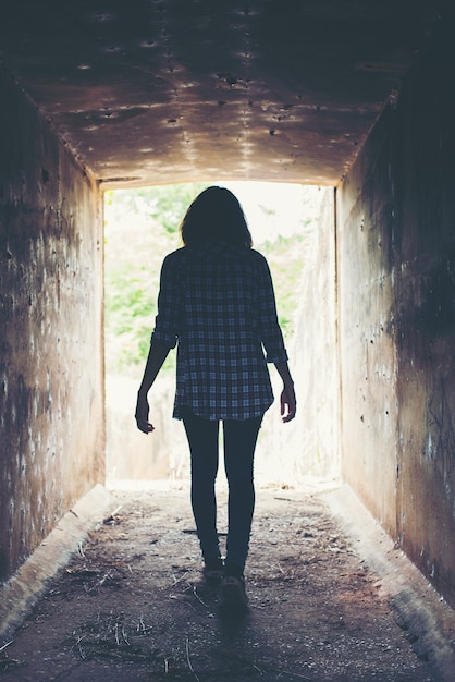 Mujer joven atravesando un túnel solitario