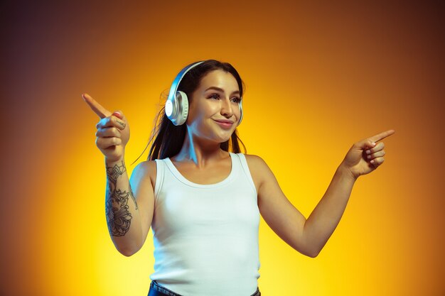 Mujer joven, con, auriculares, aislado, en, pared amarilla