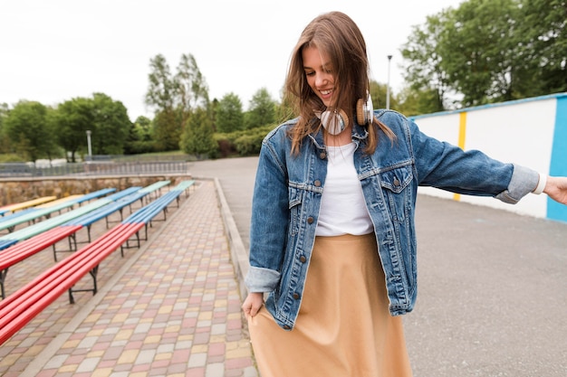 Foto gratuita mujer joven con auriculares caminando