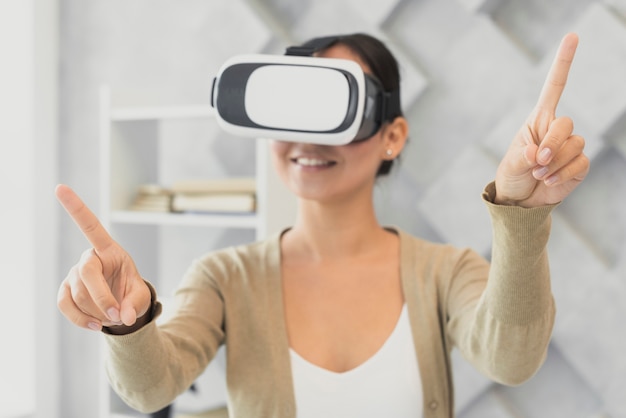 Mujer joven con auriculares virtuales apuntando