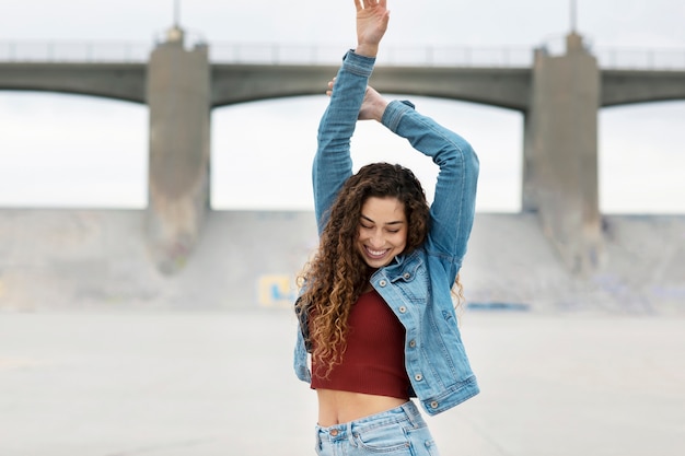 Foto gratuita mujer joven bailando mientras está en la ciudad