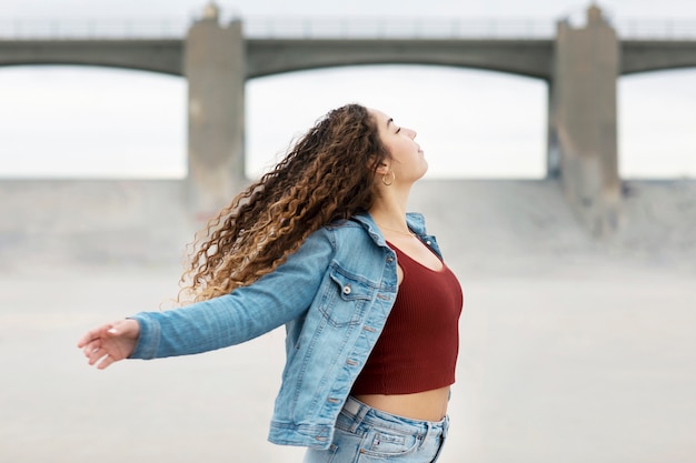 Mujer joven bailando mientras está en la ciudad