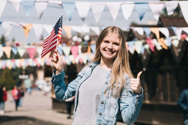 Mujer joven con la bandera de Estados Unidos en el festival