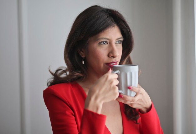mujer joven bebe en una taza de té