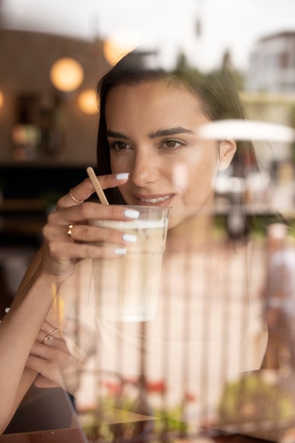 Mujer joven bebiendo café helado