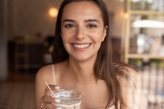 Foto gratuita mujer joven bebiendo café helado