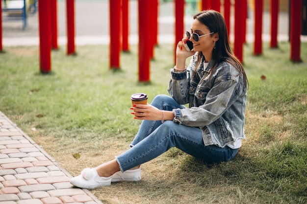 Mujer joven bebiendo café en el parque