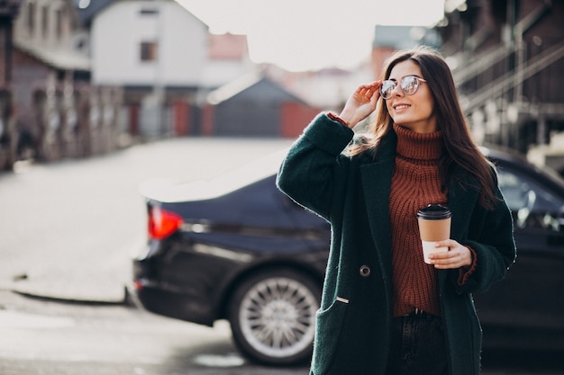 Mujer joven bebiendo café en su auto