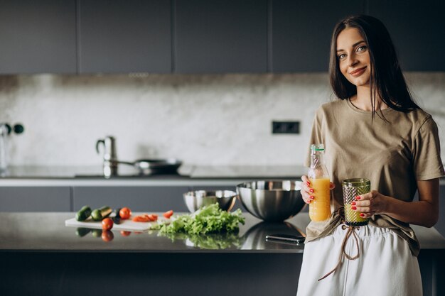 Mujer joven bebiendo jugo en casa