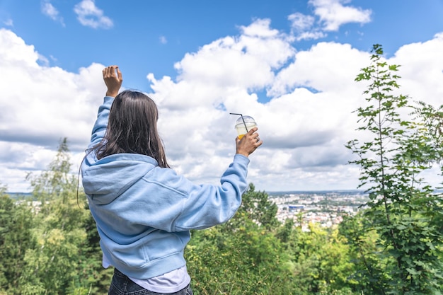 Una mujer joven bebiendo jugo de una pajita en el parque