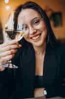 Foto gratuita mujer joven bebiendo vino blanco en un restaurante