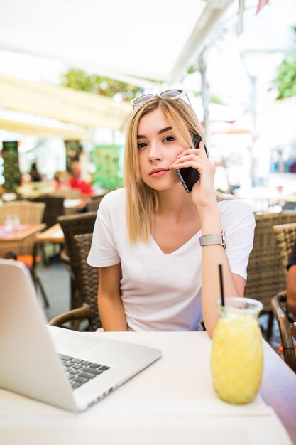 Mujer joven belleza habla con el jefe a través del teléfono celular