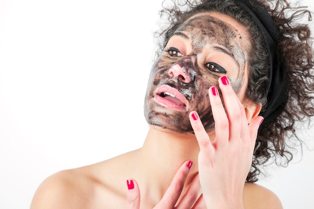 Foto gratuita mujer joven de la belleza que usa una mascarilla negra aislada en el fondo blanco