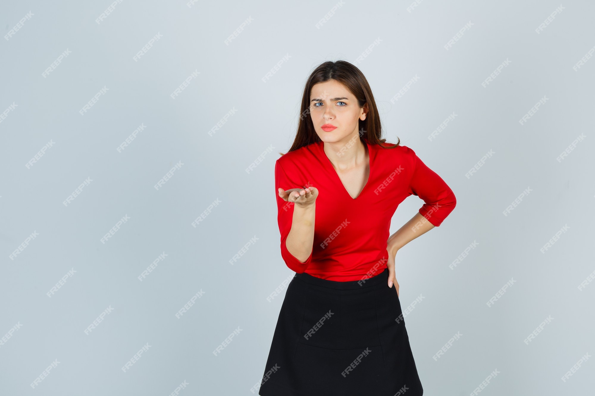 Mujer en blusa roja, falda negra estirando la mano | Foto Gratis