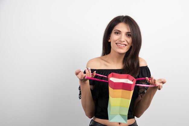 Mujer joven con bolsa de regalo.