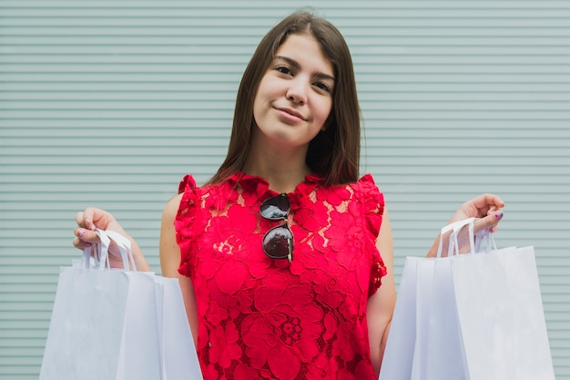 Mujer joven con bolsas de compras blancas