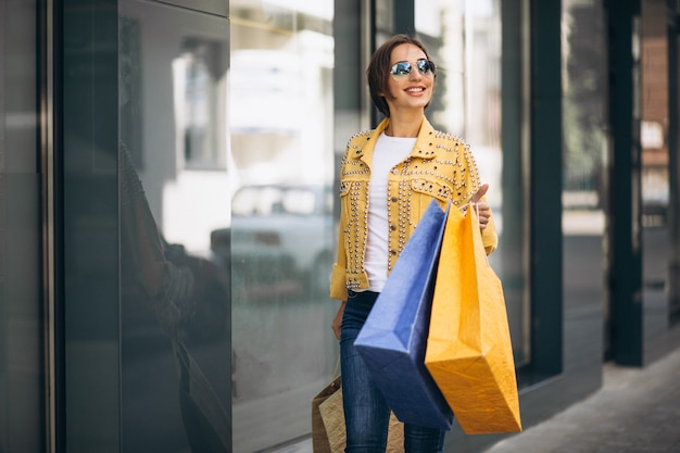 Mujer joven con bolsas de compras en la ciudad