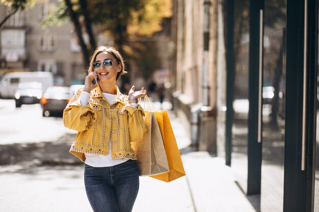 Mujer joven con bolsas de compras en la ciudad