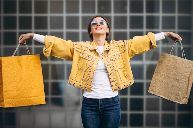 Mujer joven con bolsas de compras en la ciudad