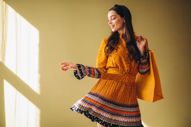 Mujer joven con bolsas de compras en un hermoso vestido