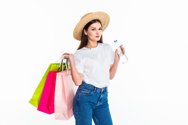 Mujer joven con bolsas de compras en la pared blanca