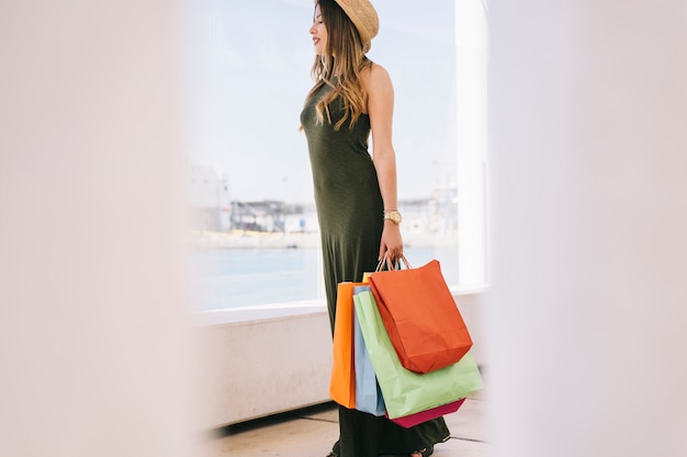 Foto gratuita mujer joven con bolsas de compras en pose natural