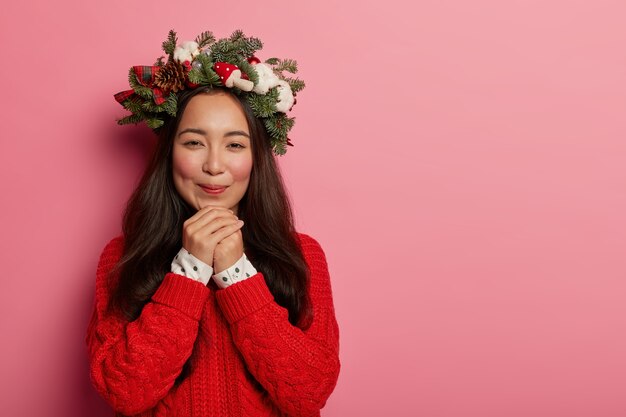 Mujer joven y bonita con corona de Navidad en la cabeza