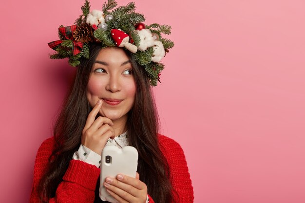 Mujer joven y bonita con corona de Navidad en la cabeza