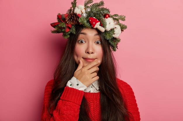 Mujer joven y bonita con corona de Navidad en la cabeza