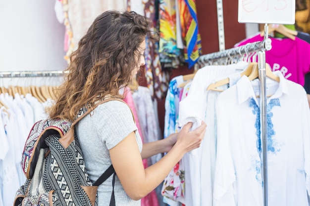 Mujer joven buscando ropa en la tienda