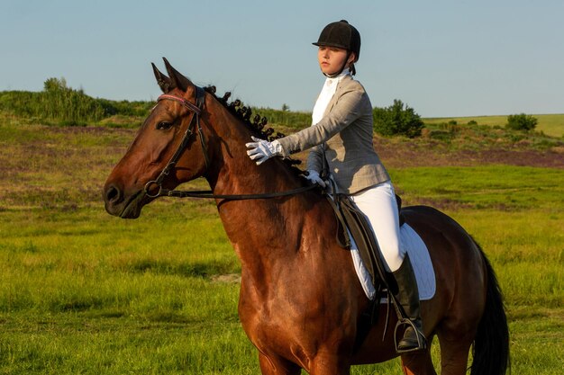 Mujer joven a caballo en el campo verde. Equitación. Competencia. Hobby
