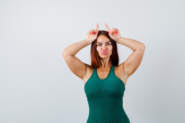 Foto gratuita mujer joven con cabello largo en un bodycon verde