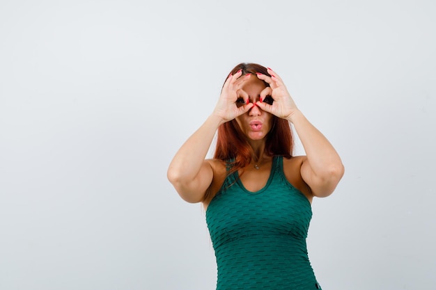 Foto gratuita mujer joven con cabello largo en un bodycon verde