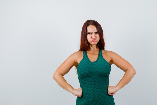 Foto gratuita mujer joven con cabello largo en un bodycon verde