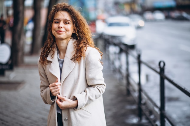 Foto gratuita mujer joven con cabello rizado fuera de la calle