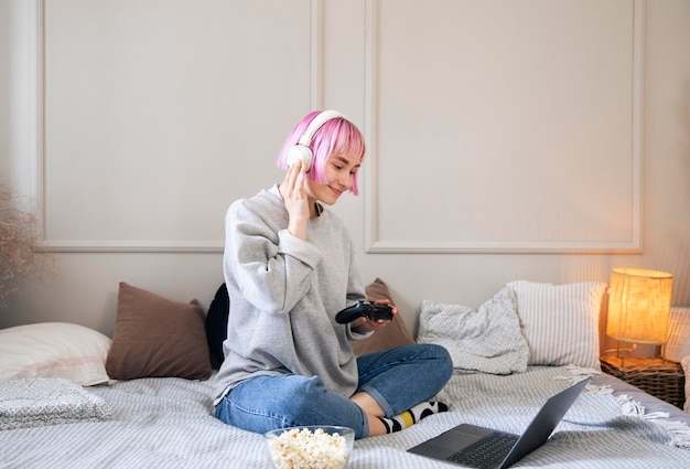 Mujer joven con cabello rosado jugando un videojuego