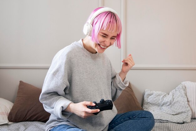 Mujer joven con cabello rosado jugando un videojuego