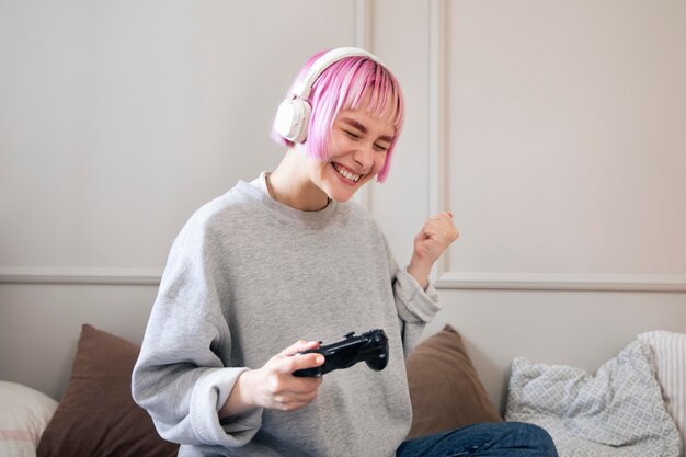 Mujer joven con cabello rosado jugando un videojuego