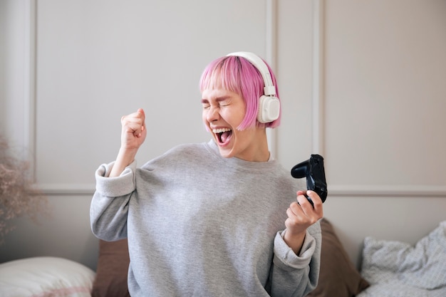 Mujer joven con cabello rosado jugando un videojuego