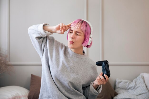 Mujer joven con cabello rosado jugando un videojuego