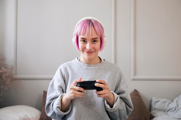 Mujer joven con cabello rosado jugando un videojuego