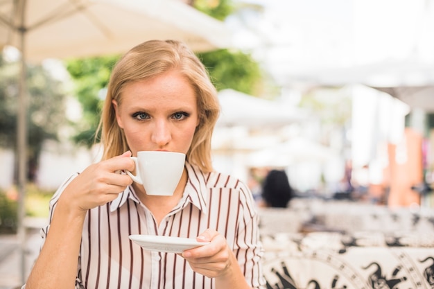 Foto gratuita mujer joven en el café al aire libre, beber una taza de café