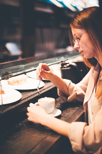 Mujer joven con café en el mostrador