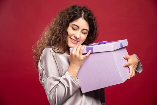 Mujer joven con caja de regalo púrpura.